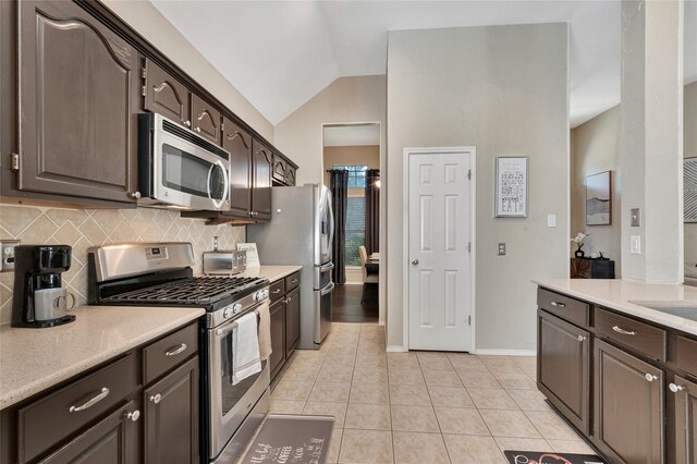 2700 Rochelle Dr, Mckinney, TX 75070 - kitchen featuring stainless steel appliances, dark brown cabinets, backsplash, light countertops, and vaulted ceiling