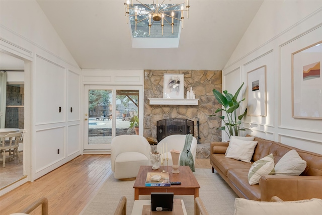 5909 Shady Hill Ln, Arlington, TX 76016 - living room featuring a decorative wall, lofted ceiling, wood finished floors, a chandelier, and a stone fireplace