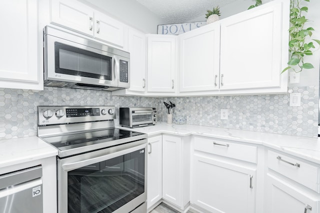 1100 Cartwright Ln, Kaufman, TX 75142 - kitchen featuring appliances with stainless steel finishes, white cabinetry, decorative backsplash, light stone countertops, and a textured ceiling