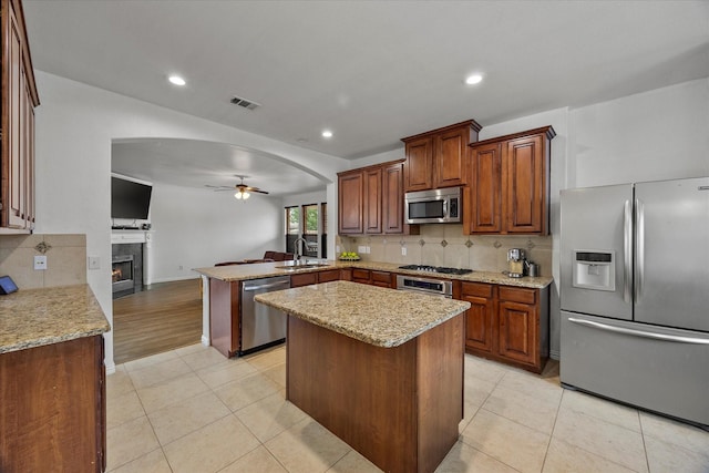 204 Leonard Way, Fate, TX 75087 - kitchen featuring appliances with stainless steel finishes, ceiling fan, a sink, arched walkways, and open floor plan