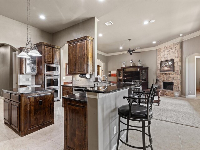 901 Egan Way Ct, Burleson, TX 76028 - kitchen with arched walkways, stainless steel appliances, open floor plan, recessed lighting, and crown molding