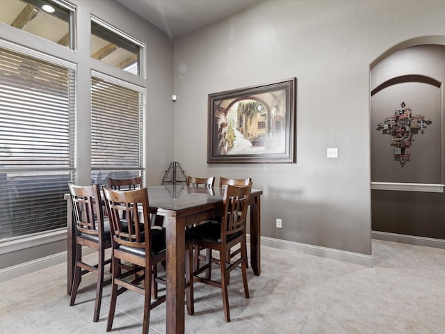 901 Egan Way Ct, Burleson, TX 76028 - dining space featuring baseboards, arched walkways, and light tile patterned floors