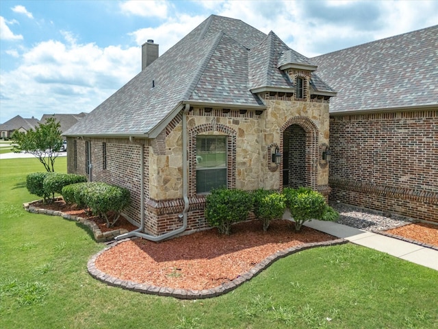 901 Egan Way Ct, Burleson, TX 76028 - view of front of home with a chimney, a front yard, stone siding, brick siding, and roof with shingles