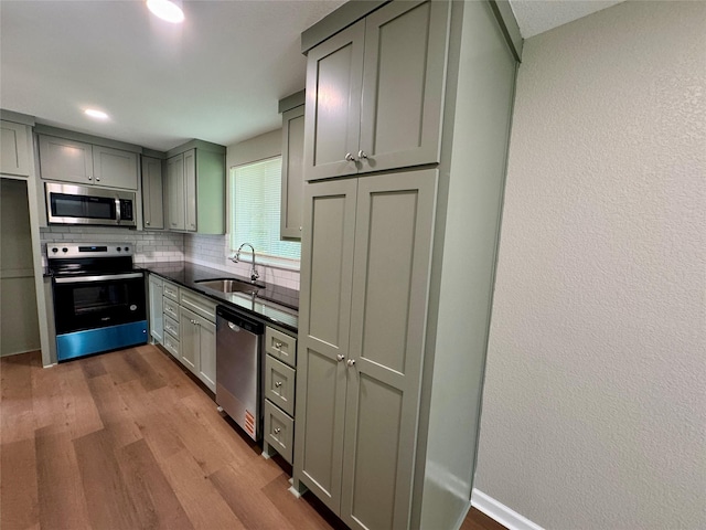 924 Gurley Ln, Waco, TX 76706 - kitchen with stainless steel appliances, a sink, wood finished floors, and backsplash