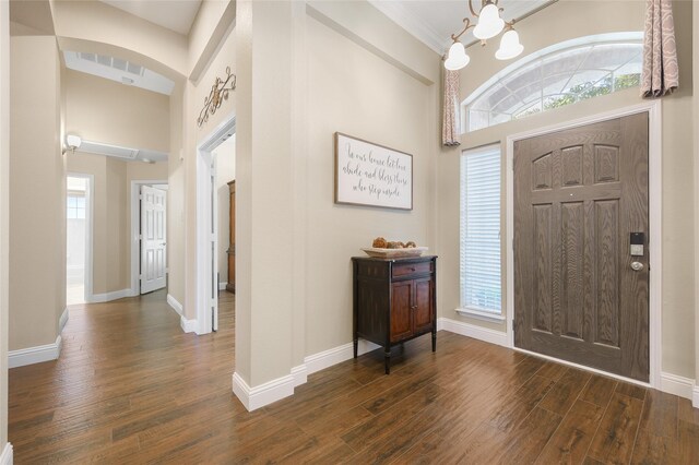 10105 Hunter Run, Frisco, TX 75035 - foyer with dark wood-type flooring, a high ceiling, a chandelier, crown molding, and arched walkways