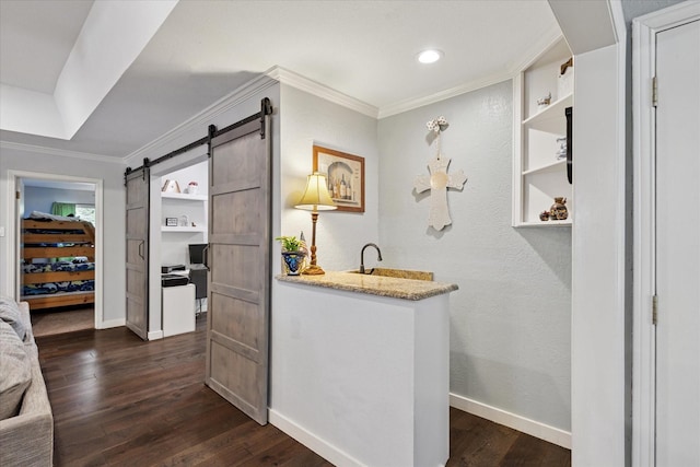 1133 Harris Ave, Hurst, TX 76053 - indoor wet bar featuring ornamental molding, dark wood-style floors, a barn door, baseboards, and a textured wall