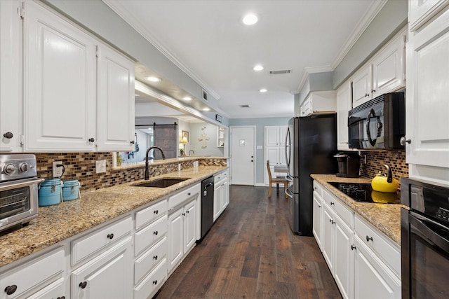 1133 Harris Ave, Hurst, TX 76053 - kitchen with a sink, black appliances, ornamental molding, white cabinets, and recessed lighting