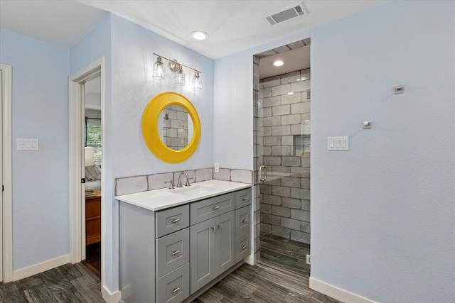 1133 Harris Ave, Hurst, TX 76053 - bathroom featuring wood finished floors, a shower stall, vanity, baseboards, and recessed lighting