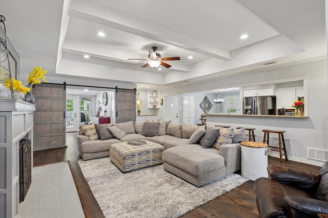 1133 Harris Ave, Hurst, TX 76053 - living area featuring a barn door, ceiling fan, wood finished floors, a tray ceiling, and recessed lighting