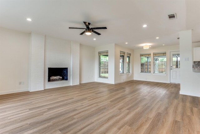 1601 Elk Grove Dr, Richardson, TX 75081 - unfurnished living room featuring light wood finished floors, a ceiling fan, recessed lighting, a brick fireplace, and baseboards