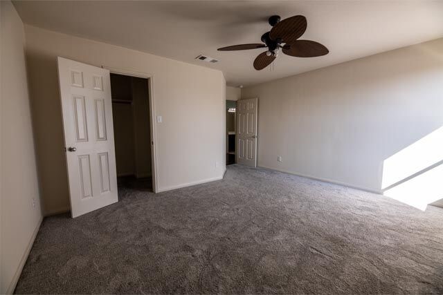 3412 Spruce St, Royse City, TX 75189 - unfurnished bedroom with carpet floors, baseboards, a walk in closet, and a ceiling fan