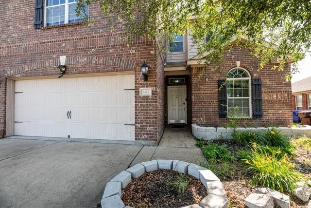 3412 Spruce St, Royse City, TX 75189 - view of exterior entry featuring brick siding, a garage, and concrete driveway