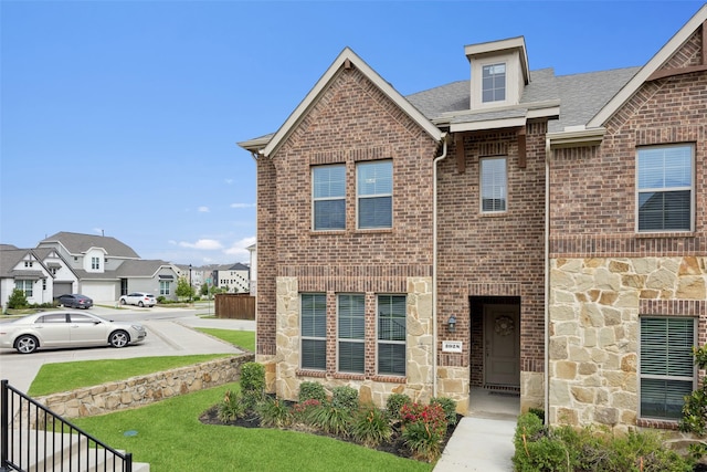 2028 Saddle Way, Mesquite, TX 75149 - townhome / multi-family property with stone siding, brick siding, a shingled roof, and a residential view