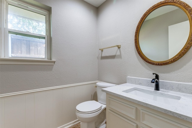 4023 Candlenut Ln, Dallas, TX 75244 - bathroom with vanity, toilet, and a wainscoted wall