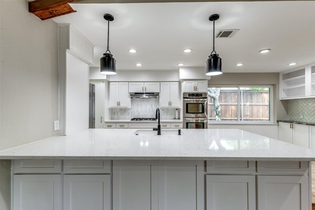 4023 Candlenut Ln, Dallas, TX 75244 - kitchen featuring a sink, tasteful backsplash, stainless steel double oven, white cabinets, and under cabinet range hood