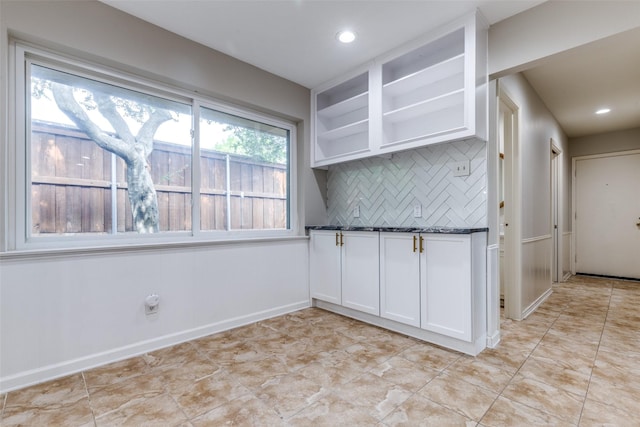 4023 Candlenut Ln, Dallas, TX 75244 - kitchen featuring dark countertops, tasteful backsplash, white cabinetry, open shelves, and baseboards