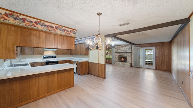 1015 Monte Carlo Dr, Grand Saline, TX 75140 - kitchen featuring electric range, a textured ceiling, a chandelier, open floor plan, and brown cabinetry