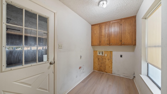 1015 Monte Carlo Dr, Grand Saline, TX 75140 - laundry room with electric dryer hookup, light wood-type flooring, hookup for a washing machine, cabinet space, and a textured ceiling