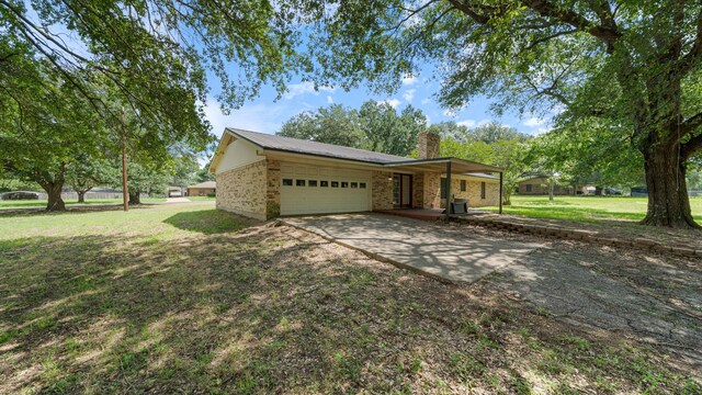 1015 Monte Carlo Dr, Grand Saline, TX 75140 - view of property exterior featuring an attached garage, a chimney, a yard, and concrete driveway