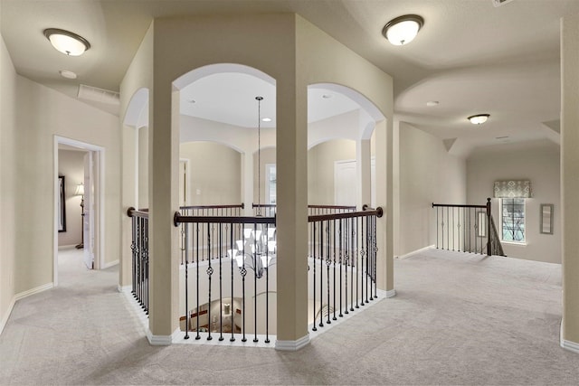 917 Navasota Trl, Mckinney, TX 75071 - hallway featuring carpet flooring, an upstairs landing, baseboards, and arched walkways