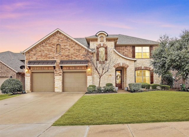 917 Navasota Trl, Mckinney, TX 75071 - french country style house featuring concrete driveway, stone siding, a lawn, an attached garage, and a shingled roof