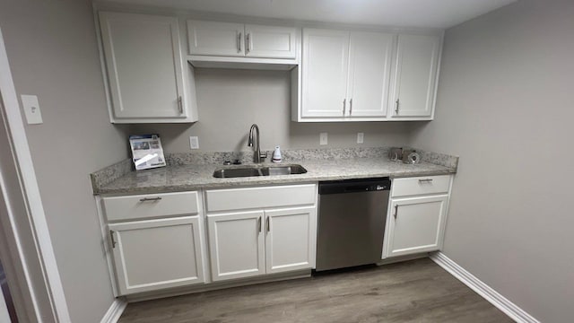 6600 Eastridge Dr Unit 117, Dallas, TX 75231 - kitchen with stainless steel dishwasher, wood finished floors, white cabinets, and light stone countertops