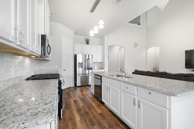 15717 Preble Rd, Fort Worth, TX 76177 - kitchen with appliances with stainless steel finishes, a sink, arched walkways, white cabinetry, and tasteful backsplash