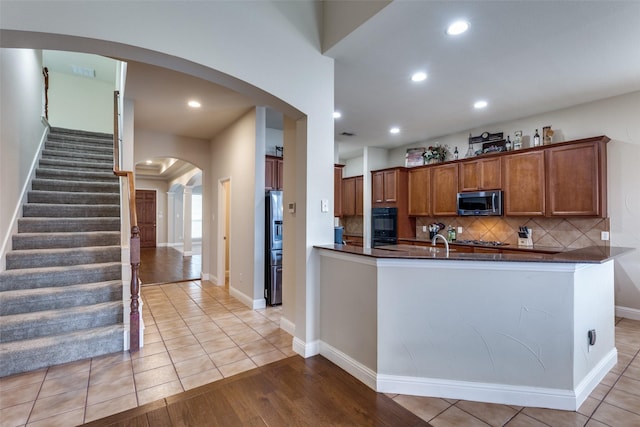 1616 Teakwood Dr, Wylie, TX 75098 - kitchen featuring stainless steel appliances, arched walkways, brown cabinetry, tasteful backsplash, and recessed lighting