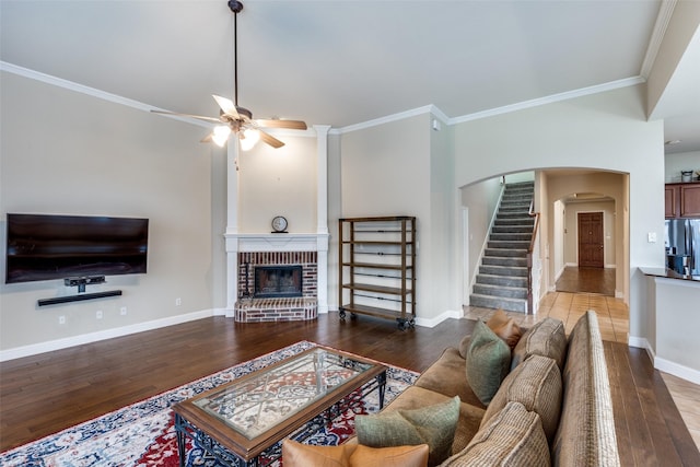1616 Teakwood Dr, Wylie, TX 75098 - living area with arched walkways, hardwood / wood-style floors, ornamental molding, ceiling fan, and a fireplace