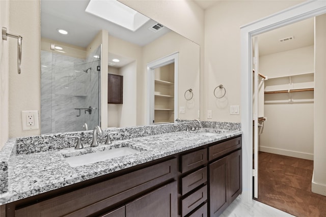 5909 Ross Ave Unit 2, Dallas, TX 75206 - bathroom with a walk in closet, a stall shower, double vanity, a skylight, and recessed lighting