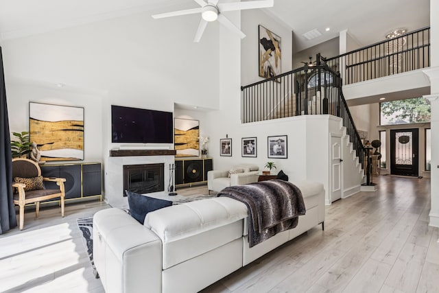 1117 Charleston Ct, Keller, TX 76248 - living room featuring stairway, a towering ceiling, ceiling fan, a premium fireplace, and light wood-style floors