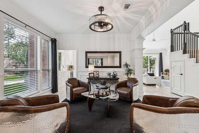 1117 Charleston Ct, Keller, TX 76248 - living area featuring wood finished floors, ornate columns, stairway, ornamental molding, and a chandelier