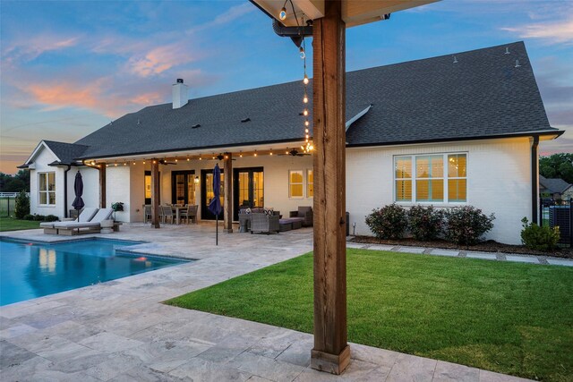 36 Mirror Lakes Ct, Gunter, TX 75058 - back of house at dusk with outdoor lounge area, a yard, a chimney, a patio area, and a shingled roof