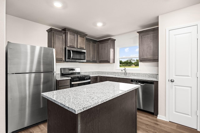 104 Southgate Dr, Terrell, TX 75160 - kitchen with stainless steel appliances, a sink, dark brown cabinets, a center island, and wood finished floors