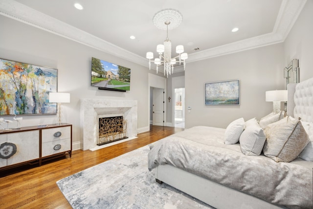 504 Bristol Dr, Allen, TX 75013 - bedroom with crown molding, wood finished floors, a chandelier, recessed lighting, and a high end fireplace