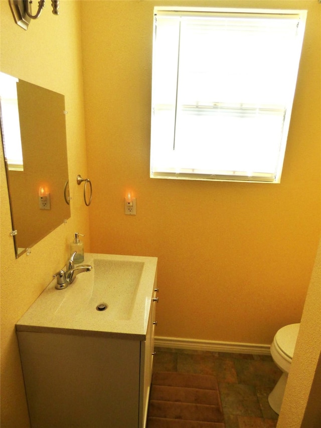 225 County Road 472, Ranger, TX 76470 - bathroom featuring vanity, toilet, and baseboards