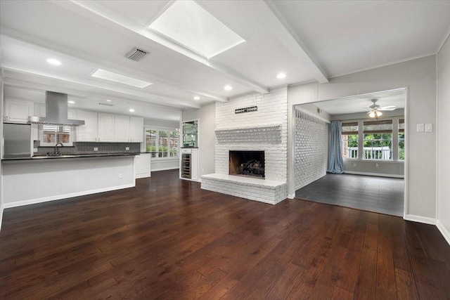 4517 Cloudview Rd, Fort Worth, TX 76109 - unfurnished living room featuring plenty of natural light, dark wood-style floors, a fireplace, ceiling fan, and beam ceiling