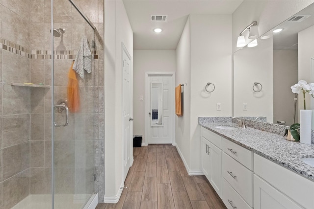 620 Ruthye Ln, Pilot Point, TX 76258 - bathroom featuring double vanity, a stall shower, wood finished floors, baseboards, and recessed lighting