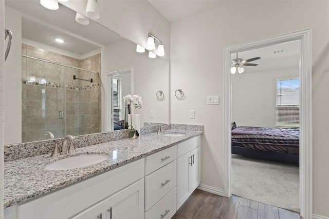 620 Ruthye Ln, Pilot Point, TX 76258 - full bathroom with connected bathroom, double vanity, a stall shower, wood finished floors, and baseboards