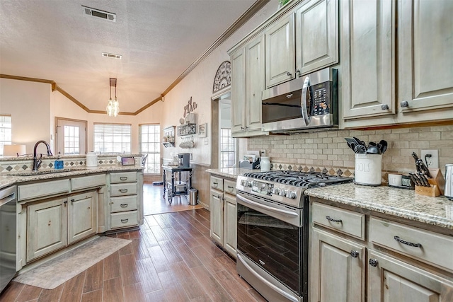 3809 Timbercrest Dr W, Burleson, TX 76028 - kitchen featuring appliances with stainless steel finishes, ornamental molding, a sink, dark wood-type flooring, and decorative backsplash