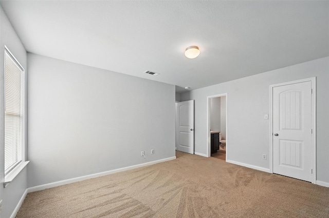4811 Pachuca Ct, Dallas, TX 75236 - unfurnished bedroom with baseboards, light carpet, and ensuite bath