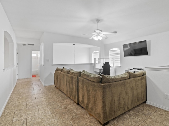 6915 Westside Pl, Sachse, TX 75048 - living area featuring baseboards, ceiling fan, light stone finish flooring, and arched walkways