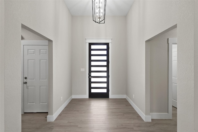 220 E 7th St, Weatherford, TX 76086 - entrance foyer with a chandelier, wood finished floors, baseboards, and a towering ceiling