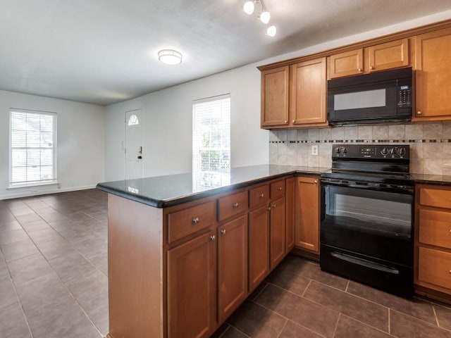 5234 Fleetwood Oaks Ave Unit 120, Dallas, TX 75235 - kitchen featuring black appliances, dark tile patterned flooring, brown cabinetry, a peninsula, and backsplash
