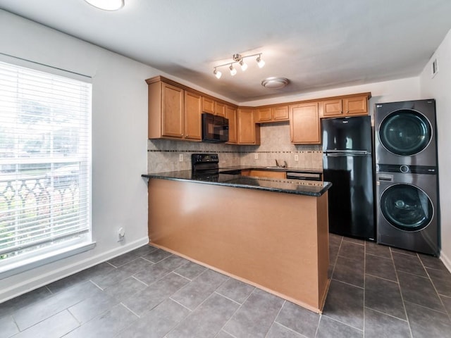 5234 Fleetwood Oaks Ave Unit 120, Dallas, TX 75235 - kitchen featuring black appliances, stacked washing machine and dryer, healthy amount of natural light, and backsplash