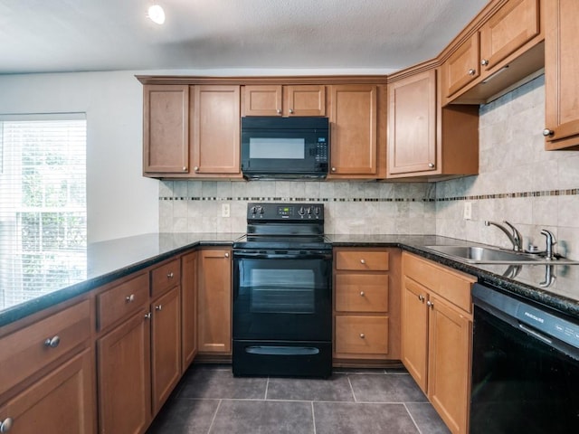 5234 Fleetwood Oaks Ave Unit 120, Dallas, TX 75235 - kitchen featuring black appliances, a sink, dark tile patterned floors, tasteful backsplash, and brown cabinetry