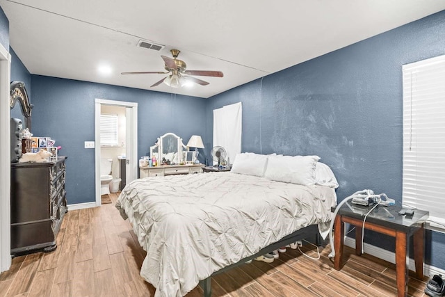 1011 Kleberg St, Alice, TX 78332 - bedroom featuring wood finished floors, a textured wall, baseboards, ensuite bathroom, and ceiling fan