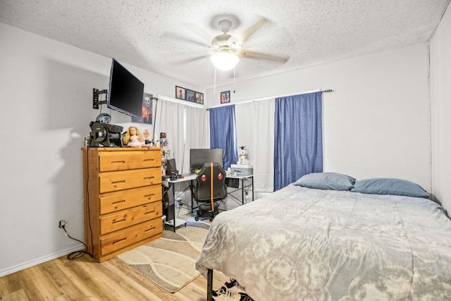 1011 Kleberg St, Alice, TX 78332 - bedroom with wood finished floors, baseboards, a textured ceiling, a ceiling fan, and a desk