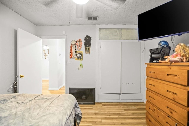 1011 Kleberg St, Alice, TX 78332 - bedroom featuring light wood-style flooring, a closet, a ceiling fan, and a textured ceiling
