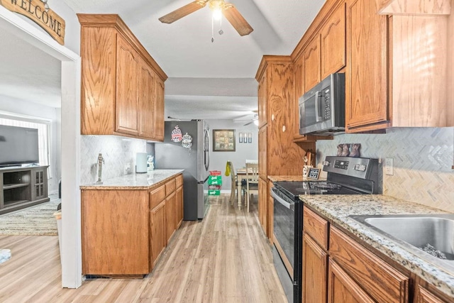 1011 Kleberg St, Alice, TX 78332 - kitchen featuring appliances with stainless steel finishes, a ceiling fan, light wood finished floors, and decorative backsplash
